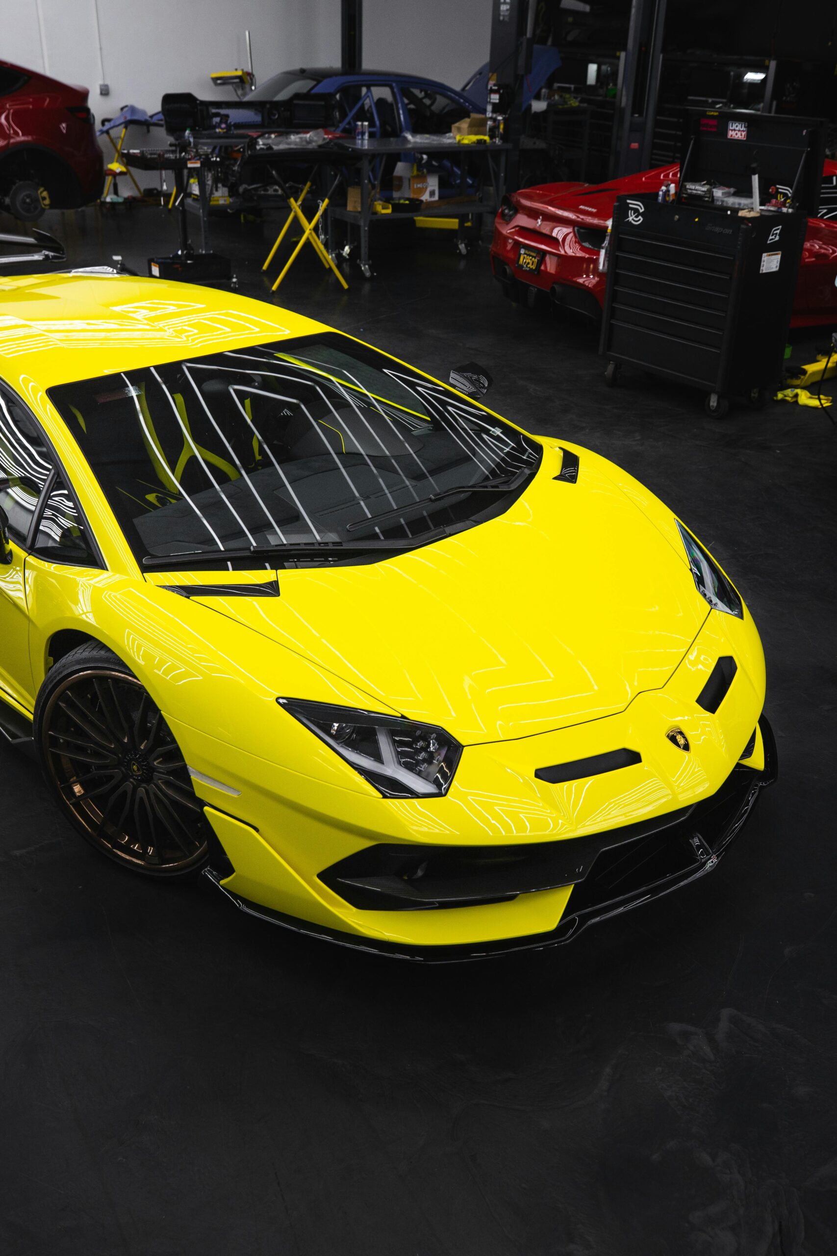 Bright yellow Lamborghini Aventador parked in a sleek, modern garage setting.